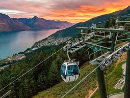 Colourful sunset view of the lake Wakatipu, resort town and mountains with gondola skyline, Southern Alps, Queenstown New Zealand, Cecil peak, Walter peak and Queenstown hill