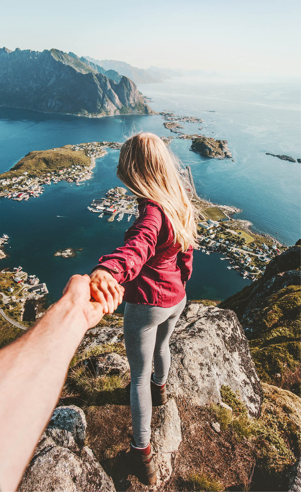 Couple follow holding hands traveling lifestyle on cliff mountain summer vacations outdoor in Norway 