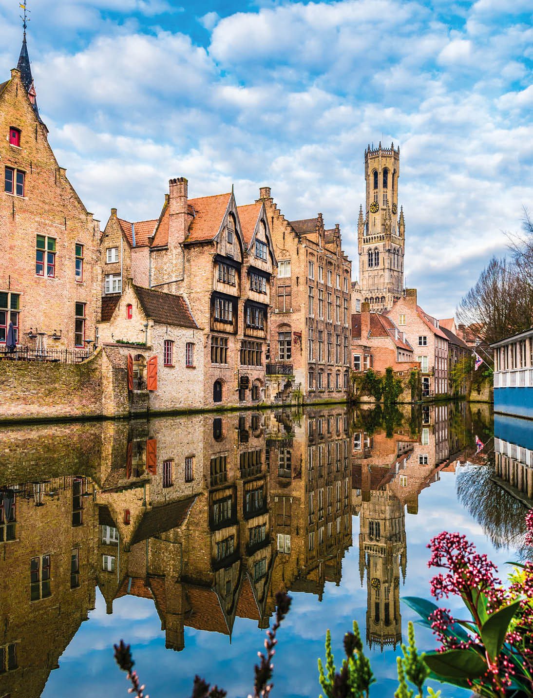 Landscape with famous Belfry tower and medieval buildings along a canal in Bruges, Belgium