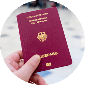 A hand holds a german passport in an airport terminal