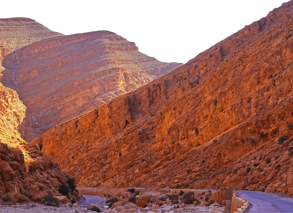 Beautiful red sandstone valley landscape, empty curved road, narrow canyon, morning sun rays - Todra (todgha) gorge, Morrocco