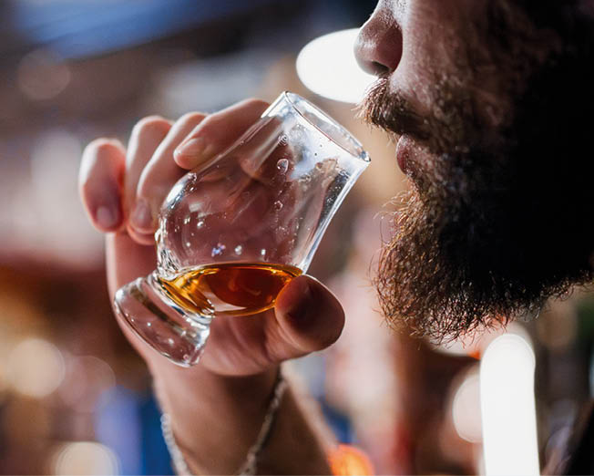 A man holding a Glencairn single malt whisky glass.