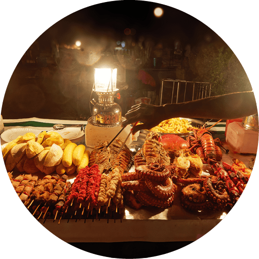 Stonetown (Tanzania, Zanzibar Archipelago) in the evening and night. Streets and harbour in old Stone town of Zanzibar City, historical colonial buildings, traditional food market, delicacy.