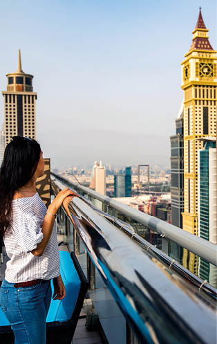 Woman enjoying Dubai downtown city view from a rooftop
