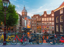 Night city view of Amsterdam canal, bridge and typical houses, Holland, Netherlands. Long exposure.
