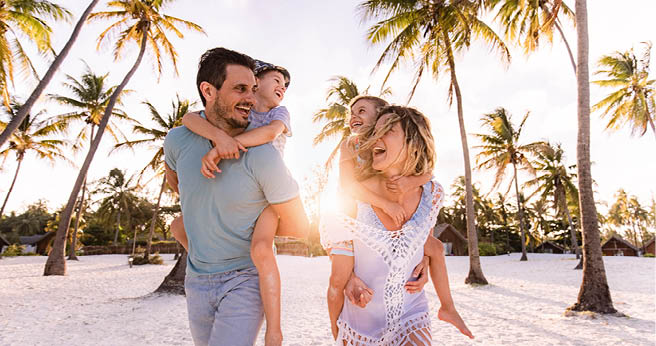 Happy parents and their small kids having fun while piggybacking on the beach in summer day. 1340416045