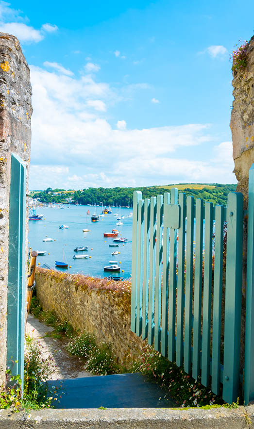 Blick durch offenes Tor auf Hafen mit Booten im Wasser