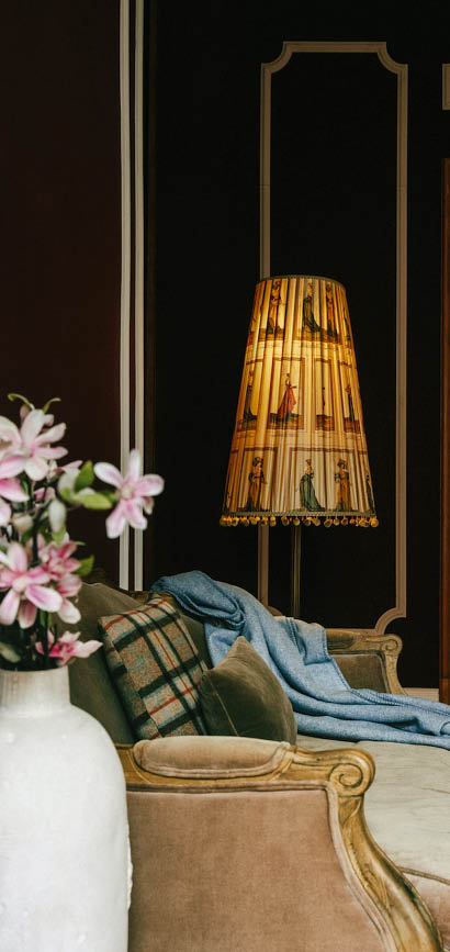 Wohnzimmer mit Sofa, Stehlampe und Blumen in Vase