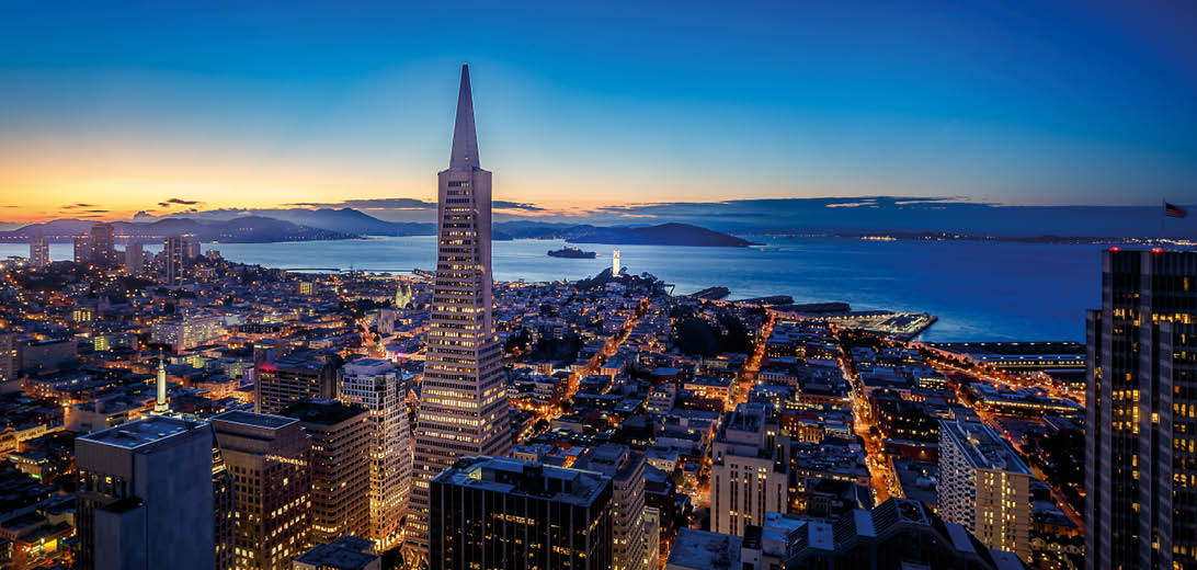 Stadtansicht bei Nacht mit beleuchteten Hochh usern am Wasser