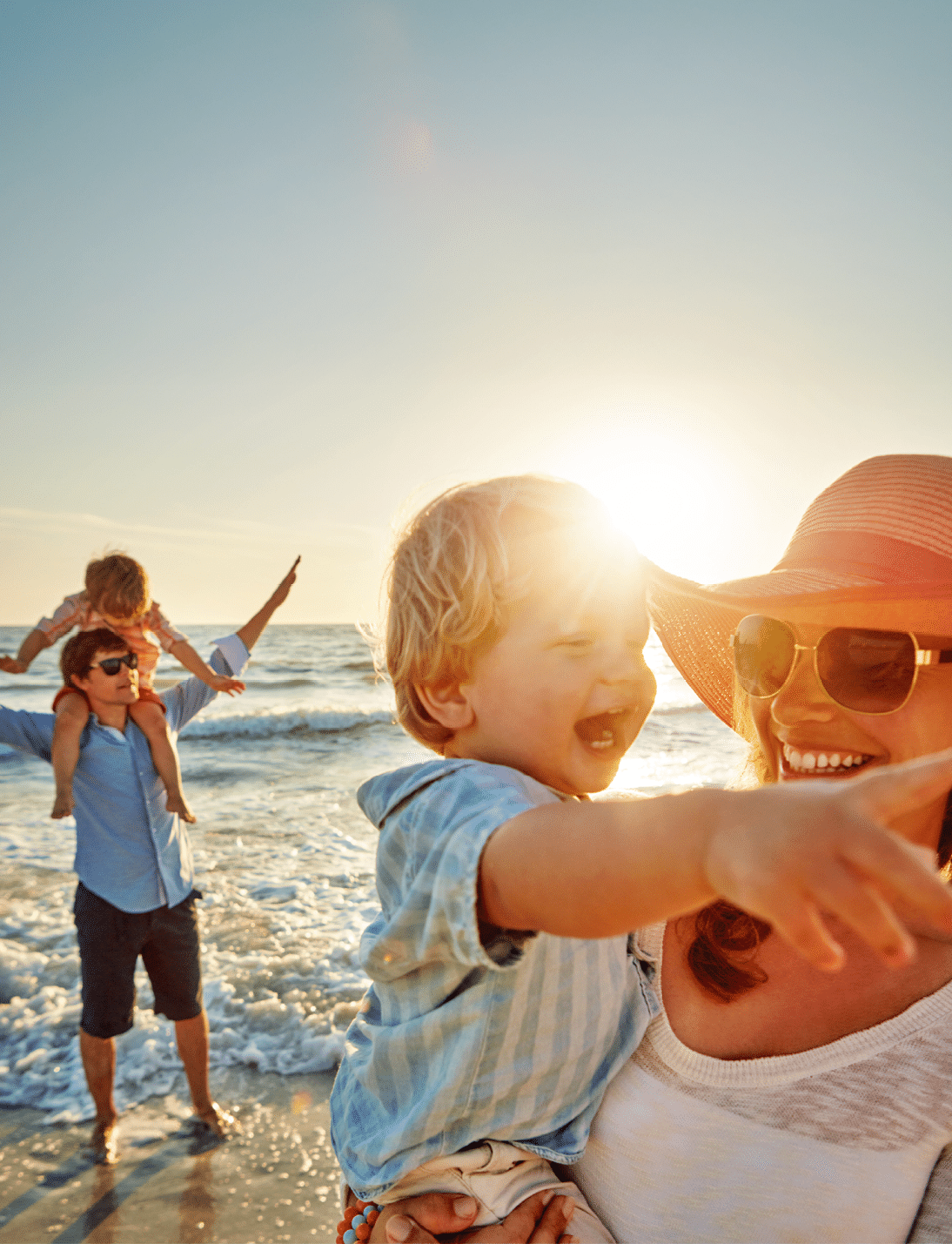 Happy family, mother and beach with little boy for bonding, outdoor holiday or weekend in nature sunset. Mom, father or children with smile for embrace, love or care in sunshine by ocean coast or sea.