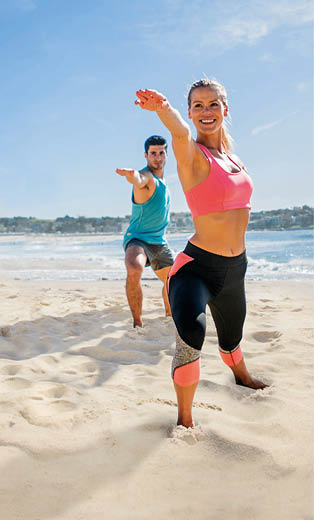 Happy group of people doing yoga exercises outdoors at the beach in Australia - healthy lifestyle concepts