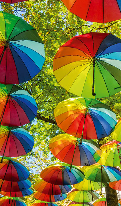 The hanging rainbow umbrellas in the sky during the gay pride in the Marais district of Paris, France