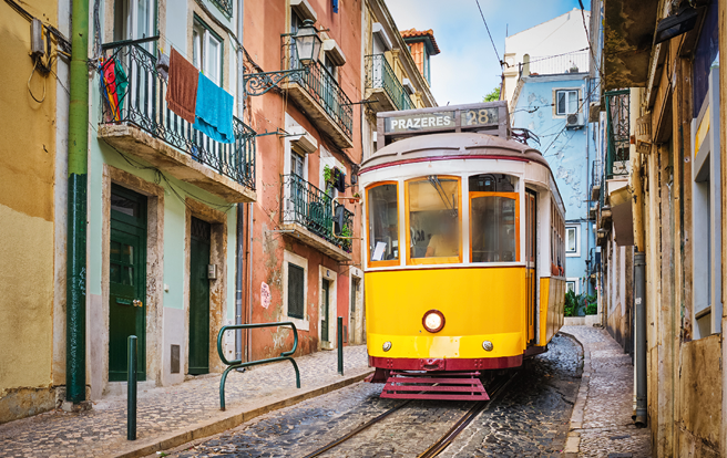 Famous vintage yellow tram 28 in the narrow streets of Alfama district in Lisbon, Portugal - symbol of Lisbon, famous popular travel destination and tourist attraction