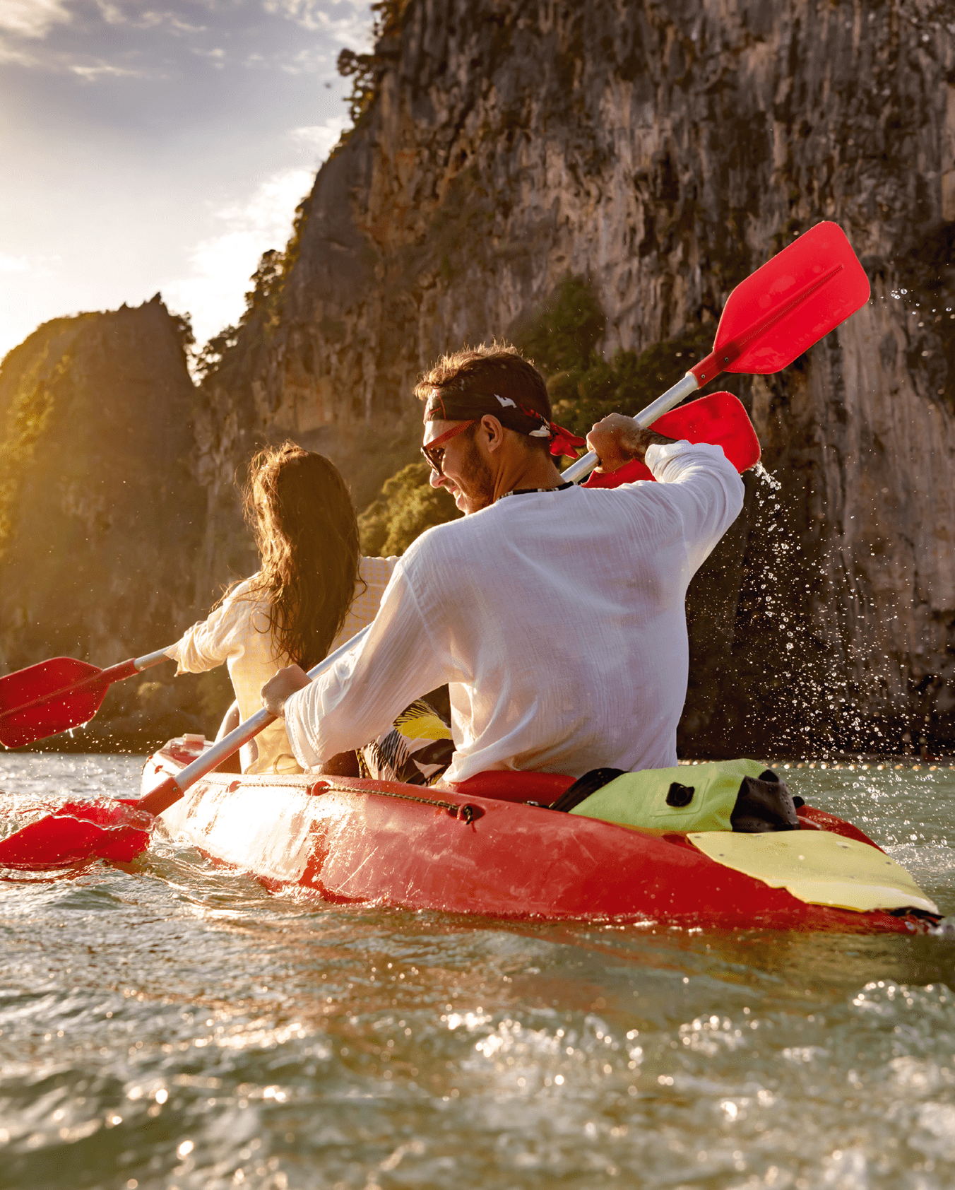 Happy young couple walks on kayak or canoe at sunset sea bay. Phranang Railay beach, Krabi, Thailand.