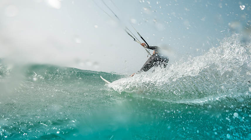 The kite surfer rides the waves of the Atlantic Ocean on the Fuerteventura island, Canary Islands