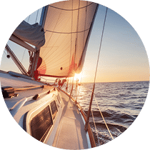 backlit sailboat in the sea sailing at sunset with a clear sky for backgrounds and designers