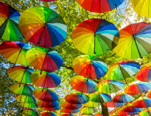 The hanging rainbow umbrellas in the sky during the gay pride in the Marais district of Paris, France