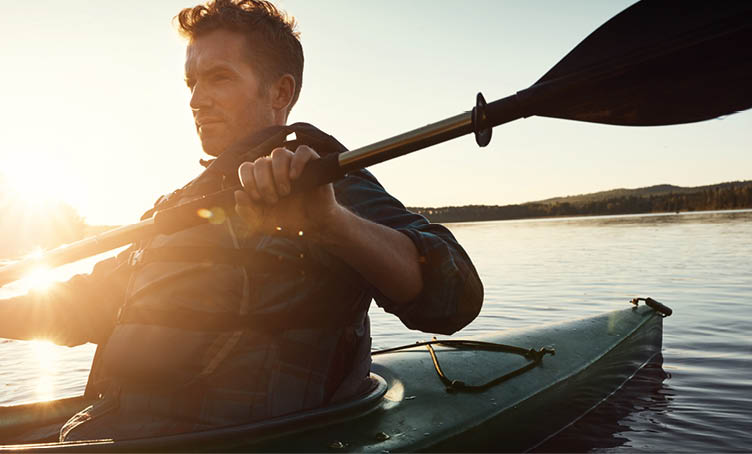 Man, paddle and nature with lake or kayak or water sports, thinking and river journey on summer vacation. Person, canoeing and happy on holiday in outdoor with sunshine, adventure and rowing for tour.