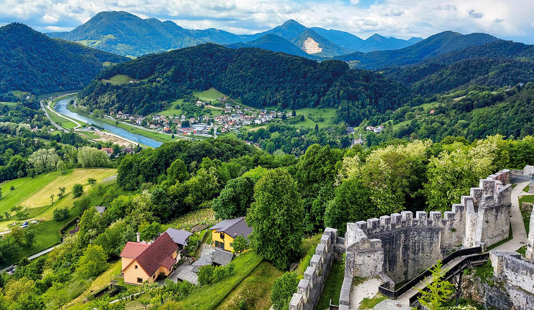 view from Celje Upper Castle to river Savinja and green hills. Landscape in Slovenia. Cloudy sky.
