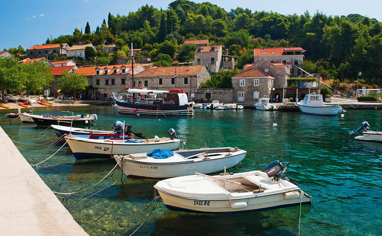 Photo of boats in the port, Sipan Island (Sipano), Elaphiti Islands, Dalmatian Coast, Croatia. This photo shows boats in the port at Sipan Island in the Elaphiti Islands. The Elaphiti Islands are a small archipelago situated just a short boat crossing from Dubrovnik on the Dalmatian Coast of Croatia. For their quiet, rustic villages, quaint cathedrals and the inviting, blue, crystal clear Adriatic Sea, visiting Sipan (Sipano), Kolocep (Kalamota) and Lopud Island, the three main islands in the Elaphiti Islands makes for a fantastic day trip from Dubrovnik. Sipan (Sipano) is the largest of the Elaphiti Islands being home to c450 people. Arriving into one of the two ports, filled with fishing boats and sailing boats, Sipan (Sipano) has the captivating feel of a typical, quiet Croatian island.