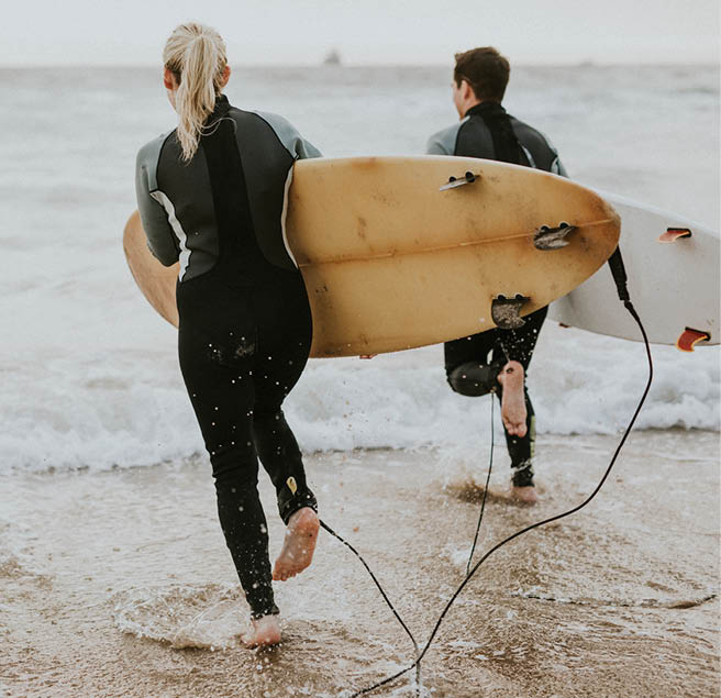 Surfers running towards the sea