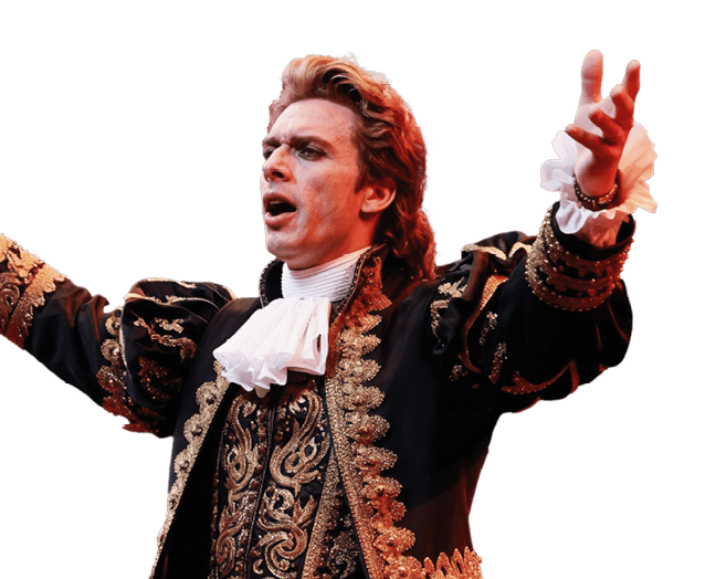 Male opera singer performs passionately on stage in ornate baroque costume. Dramatic gestures and vocalization captivate audience with, powerful voice and grand performance artistry.