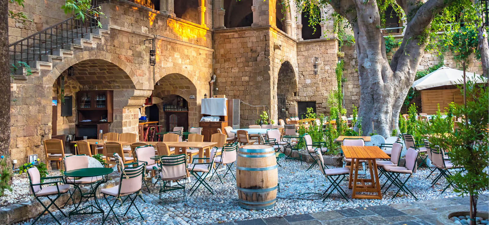 Peaceful sitting under tree among medieval buildings in City of Rhodes (Rhodes, Greece)