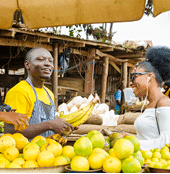 a young handsome african man feeling excited as he sells to his beautiful customer while his colleague hold a point of sales machine