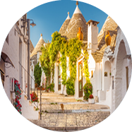 Wei get nchte H user mit Kegeld chern, Pflanzen und Katzen in gepflasterter Gasse.