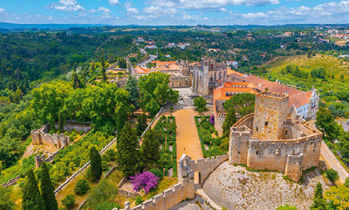 Luftaufnahme des Klosters des Christus in der portugiesischen Stadt Tomar, mit Gartenanlagen in gr ner H gellandschaft.