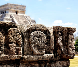 Steinreliefs vor Maya-Pyramide: In Stein gemei elte Totenk pfe vor der Tempelpyramide von Chich n Itz .