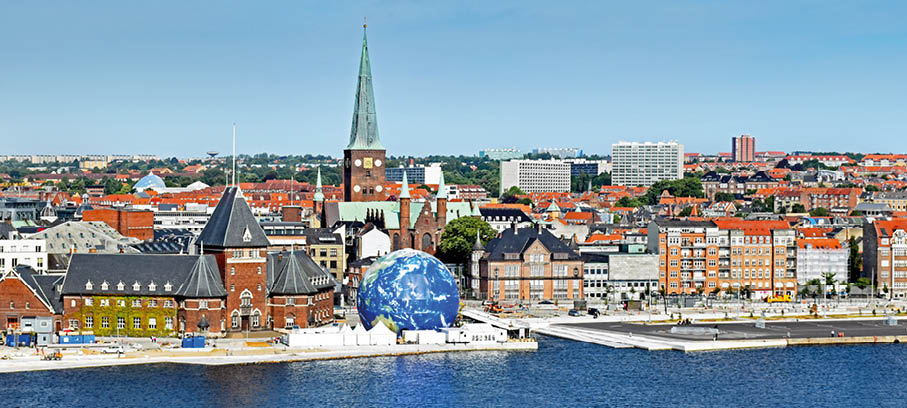 Aarhus, D nemark: Skyline mit roten Ziegeld chern, Kirchturm und gro er blauer Erdkugel-Skulptur am Wasser.