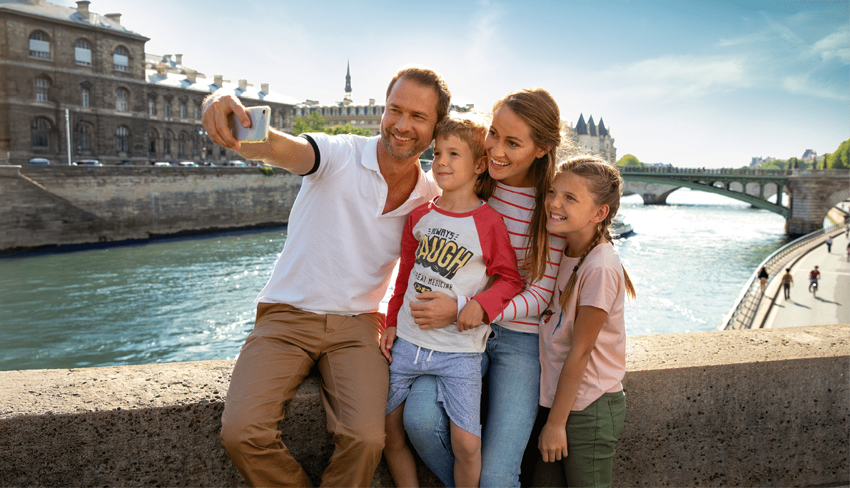 Familie sitzt auf einer Br cke und macht ein Selfie