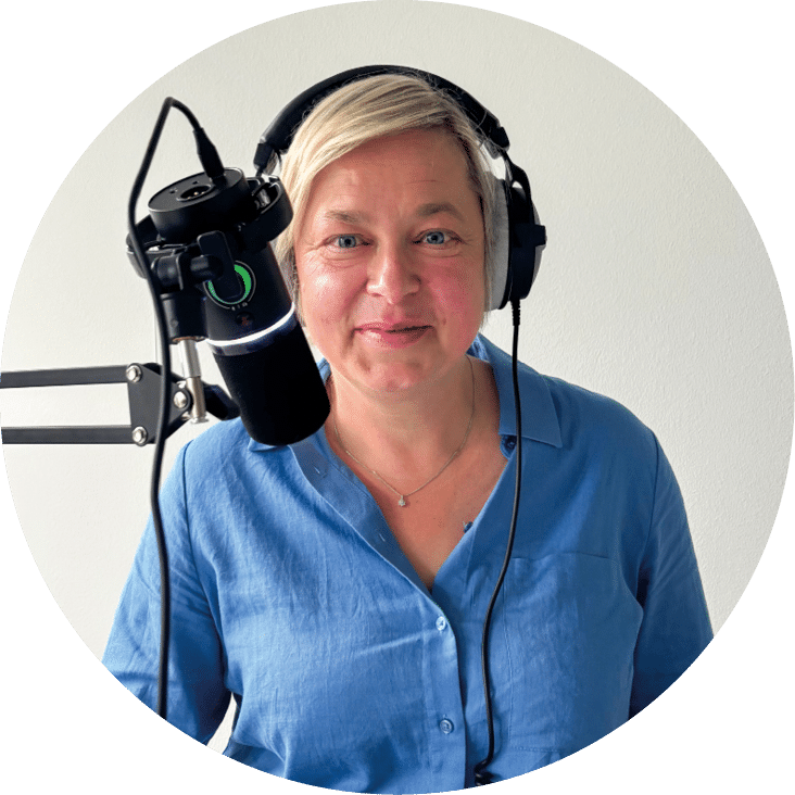 Claudia Baudisch mit Kopfh rern steht vor Mikrofon mit Manuskript, bereit zur Aufnahme.