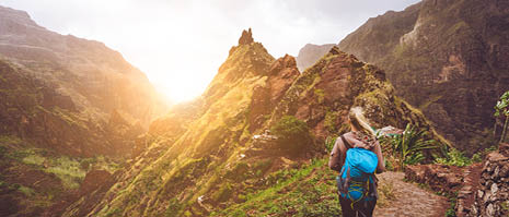 Girl walking down along the trekking route to verdant Xo-Xo valley. Warm sunlight seable on horizont. Santo Antao Island Cape Verde.