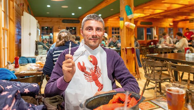 Man enjoying eating Lobster in Maine.