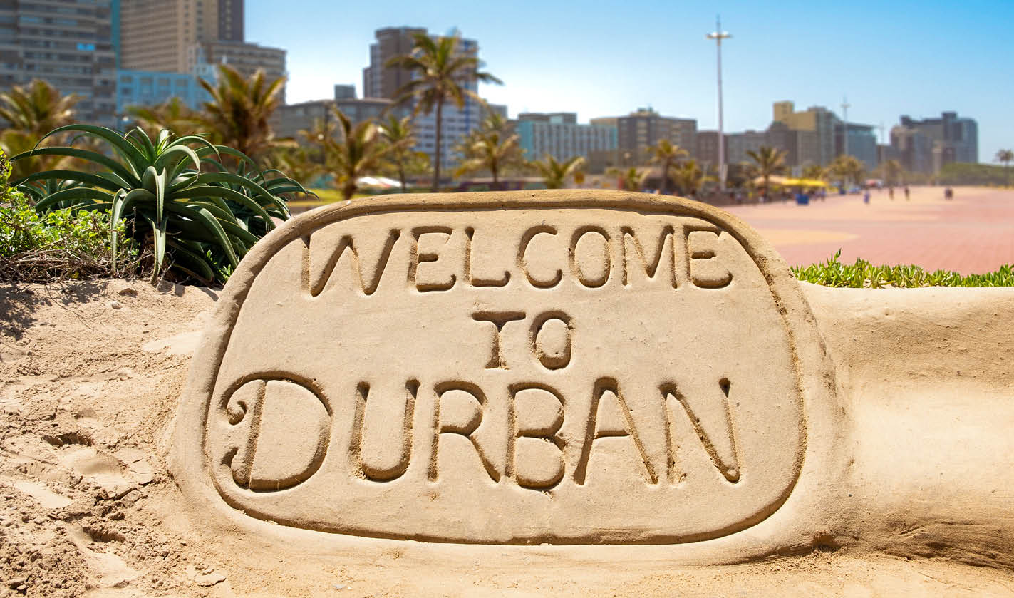 Welcome to Durban sand sculpture with skyline of Durban bay of plenty in the background