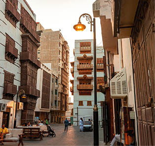 Men and women lounging outside multi-storey buildings in Al Balad