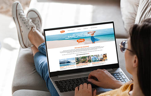 Young woman using laptop screen blank, mockup lying on the sofa at home