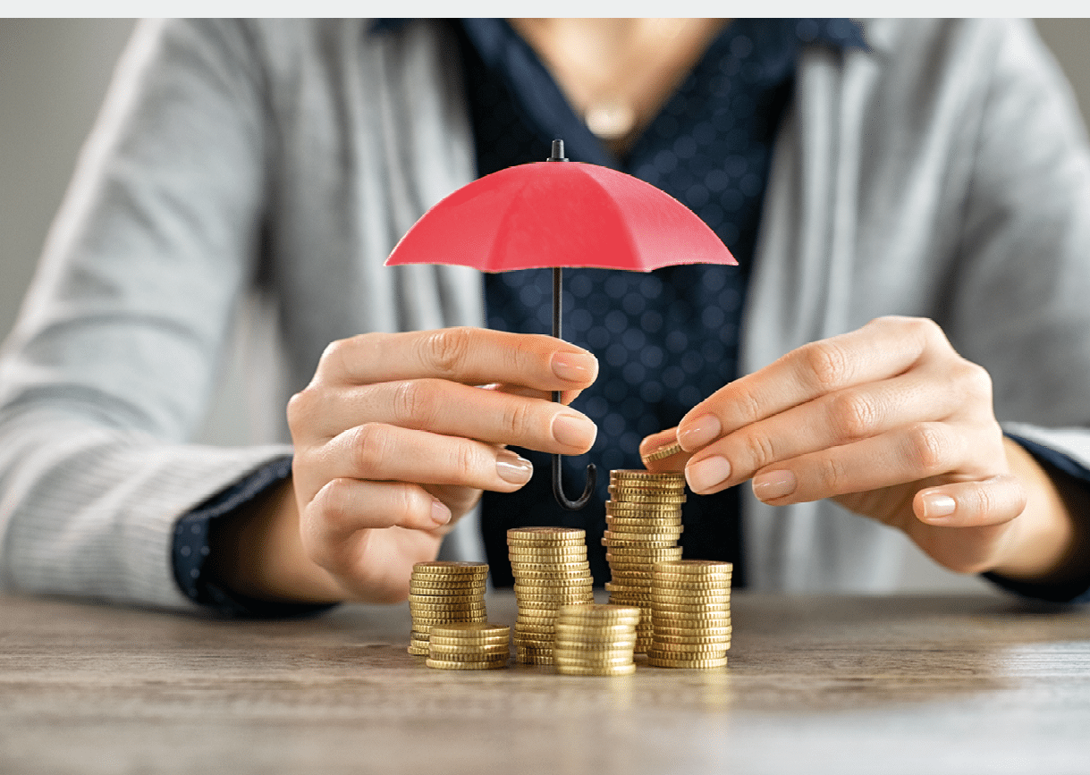 Young woman hands holding red umbrella over stacked coin on table. Female hand holding a small umbrella to protect heaps of coins while saving them. Financial security and savings protection concept.