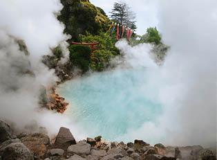 Dieses Bild zeigt eine hei e Thermalquelle in Beppu, Japan – dicht aufsteigender Dampf umgibt das t rkisfarbene Wasser, w hrend im Hintergrund ein rotes Torii-Tor und farbenfrohe Koinobori (Fisch-Fahnen) typisch japanisches Flair vermitteln. Die ppige Vegetation rundet die Szenerie ab.