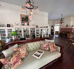 Historisch eingerichteter Wohnraum mit Kamin, antikem Sofa, Globus, B cherregalen und Grammophon.