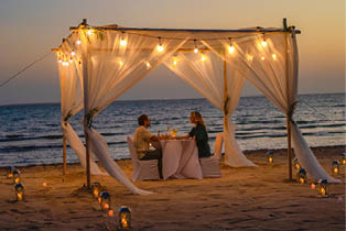 A young couple having a romantic candlelit dinner on the beach in the Farasan Islands