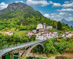 Scenic alpine village in Pordenone, Italy. Arc bridge and old houses on the mountain foot. Chievolis village near Meduno.