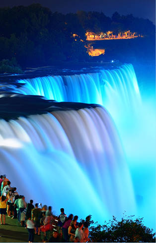 Niagara Falls lit at night by colorful lights