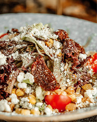 vegetable salad with lettuce dried tomatoes goat cheese raisins cherry tomato