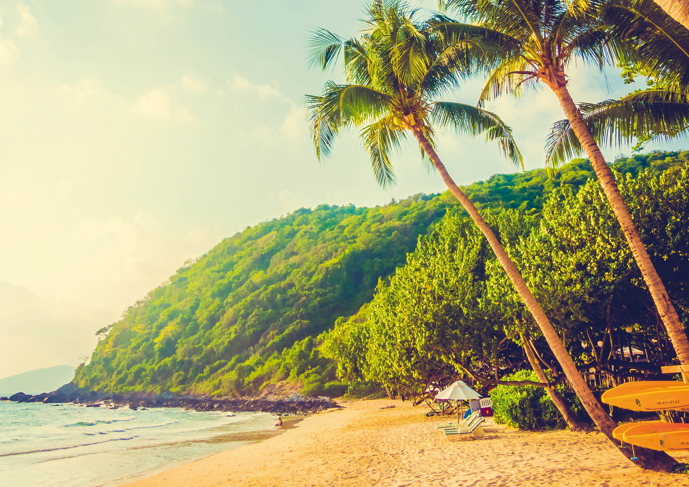 Tropische Strand- und Meereslandschaft mit Kokospalmen, Sonnenschirm und Stuhl