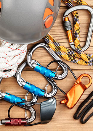 Climbing equipment on wooden background