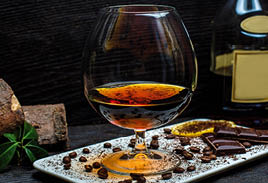glass of cognac and chocolate bars