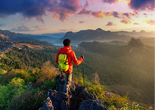Backpacker standing on sunrise viewpoint at Ja Bo village, Mae hong son province, Thailand.
